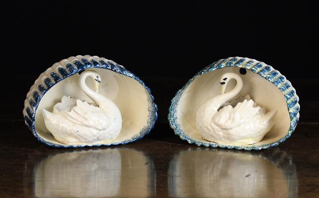 A Pair of 19th Century Creamware Wall Pockets modelled as swans contained in an ovoid open front