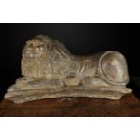 An 18th Century Oak Carving of a Recumbent Lion with traces of residual paintwork,