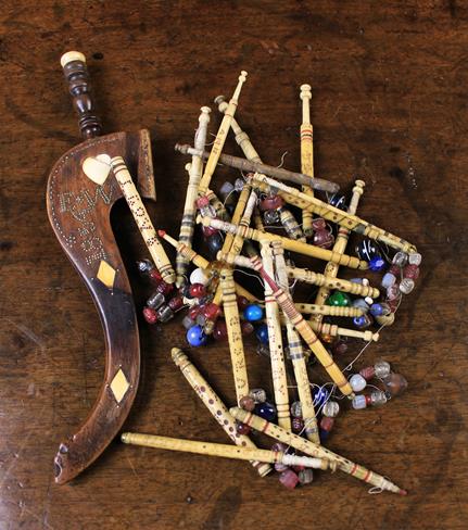 A 19th Century Mahogany Goose Knitting Sheath and a collection of turned bone lace maker's bobbins.