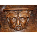 A Misericord finely carved with a Green Man's face mask, 7 in (18 cm) high, 9¾ in (25 cm) wide,