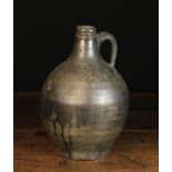 A Late 17th Century Dark Glazed Stoneware Flagon 12½ in (32 cm) in height.