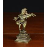 A Small Antique Bronze Statue of a young dancing Krishna holding a ball of butter in the upturned