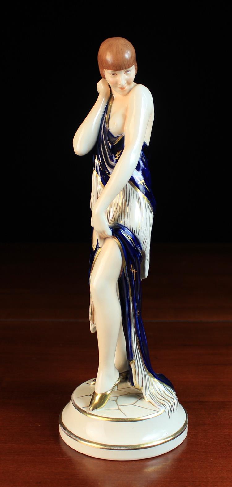 An Art Deco Style Royal Dux Figure of a Semi-Naked Female Figure standing on a round base draped in