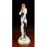 An Art Deco Style Royal Dux Figure of a Semi-Naked Female Figure standing on a round base draped in