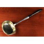 A 19th Century Russian Silver Ladle dated 1884, with a gilded oval bowl on a turned ebony handle,