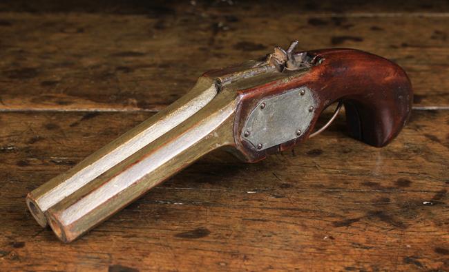 A 19th Century Metamorphic Mahogany Shoe Jack carved in the form of a double barreled pistol hinged