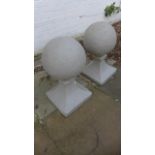 A pair of stone effect ball pier caps in two parts, 60cm tall x 30cm diameter