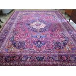 A hand knotted woolen Meshed rug - 4.06m x 3.14m