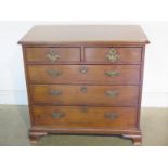 A Georgian walnut small chest with two short over three long drawers on bracket feet with brass