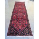 A hand knotted woolen Hamadan runner - 2.98m x 0.83m