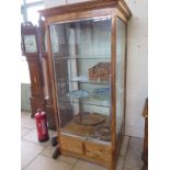 A good quality modern oak shop display cabinet with three internal shelves, two sliding lockable