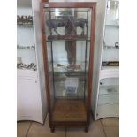 A mahogany shop display cabinet with a single glazed door with lock and key and three internal