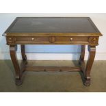 An oak writing table in the regency style the top inset with a Greek key tooled black writing