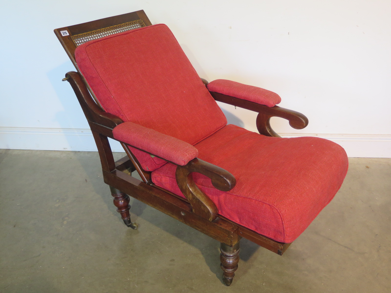 A mahogany framed campaign chair, cane back and seat folding, raised on turned supports