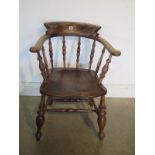 A 19th century ash and elm smokers bow armchair with a double stretcher