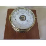A Stockburger ships barometer in circular brass case on wooden mount