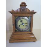 An oak mantle clock striking on a gong