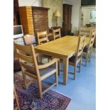 An extending oak dining table with six chairs including two carvers with leather seats - Table