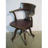 An early 1900's swivel office chair with a padded seat