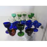 A quantity of glass and china eye baths examples include amber, blue, green and clear glass -