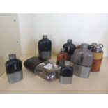 A collection of seven hip flasks and a four bottle set in a leather case, largest flask 19cm long,