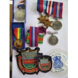 A collection of four WWII medals all unnamed, ribbons , Normande medal, and two badges, a