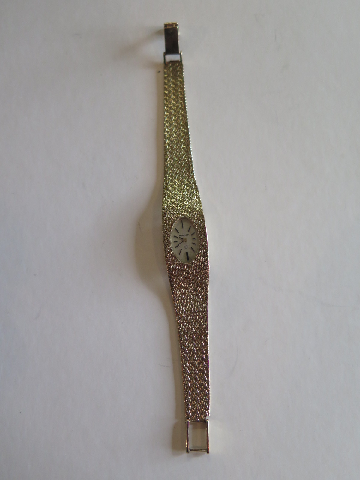 A ladies 9ct gold Omega wrist watch with oval silvered dial - 650 watch movement winding crown loose