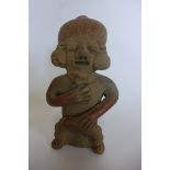 A Pre-Columbian or later figure with ear spools and head-dress, 18cm tall with restorations