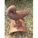 A terracotta dove roof tile ridge finial depicting a dove looking down - 24cm H x 37cm W