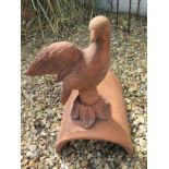 A terracotta dove roof tile ridge finial depicting a dove looking forward - 24cm H x 39cm W