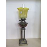 A four pillar brass oil lamp with yellow glass etched shade, 73cm tall, minor chips to shade base,