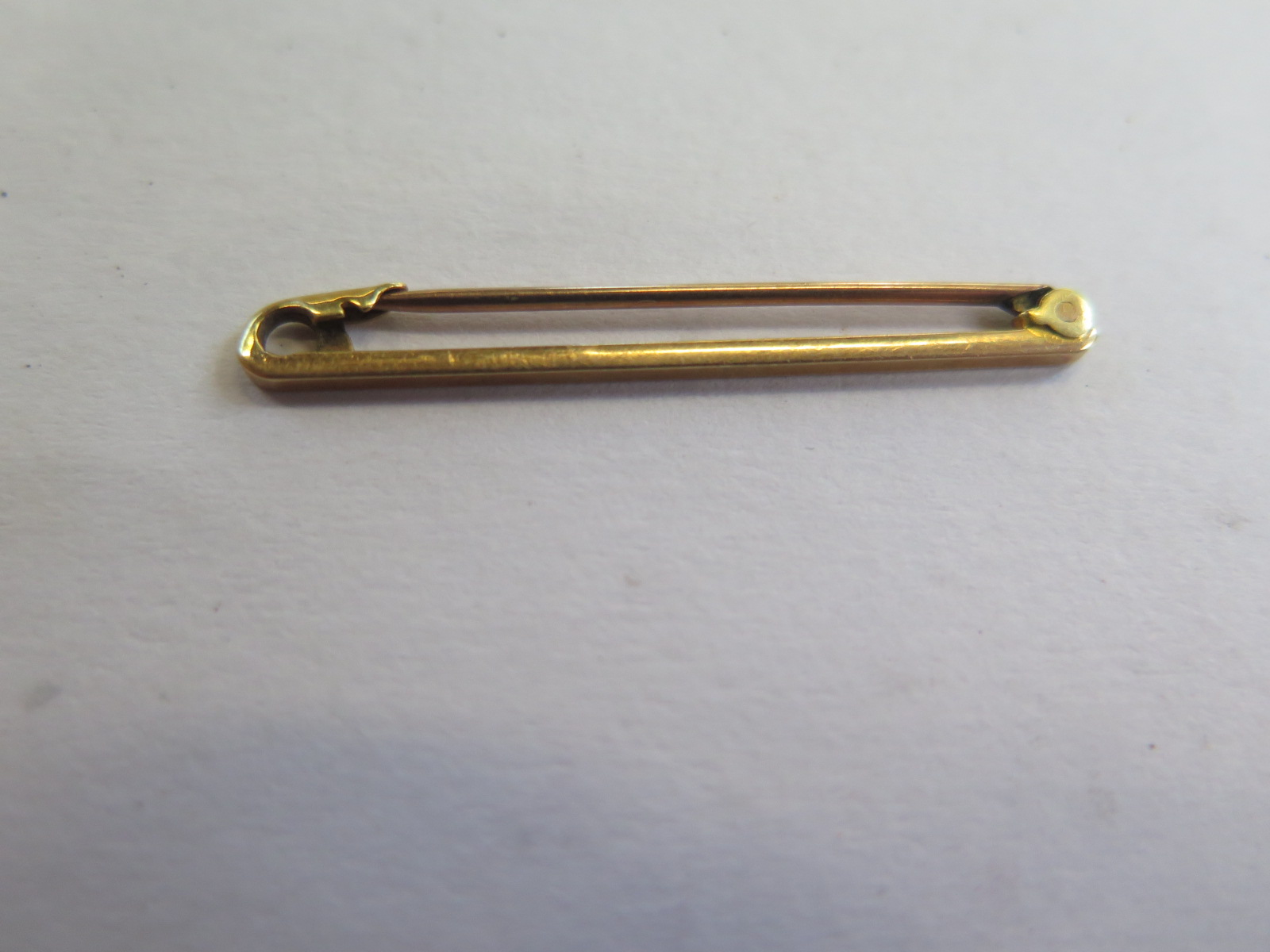 A 15ct gold bar brooch, 38mm long, approx 1.4 grams, good condition, marked 15ct