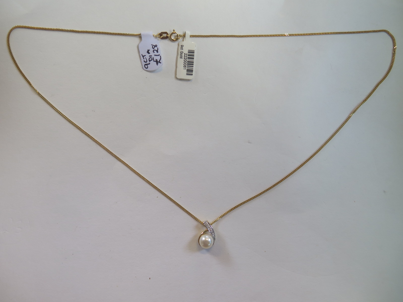 A 9ct yellow gold pearl and single diamond pendant on 9ct yellow gold chain, 44cm long, pearl approx