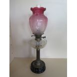 An oil lamp with an etched cranberry shade and clear glass font, 66cm tall, overall good condition