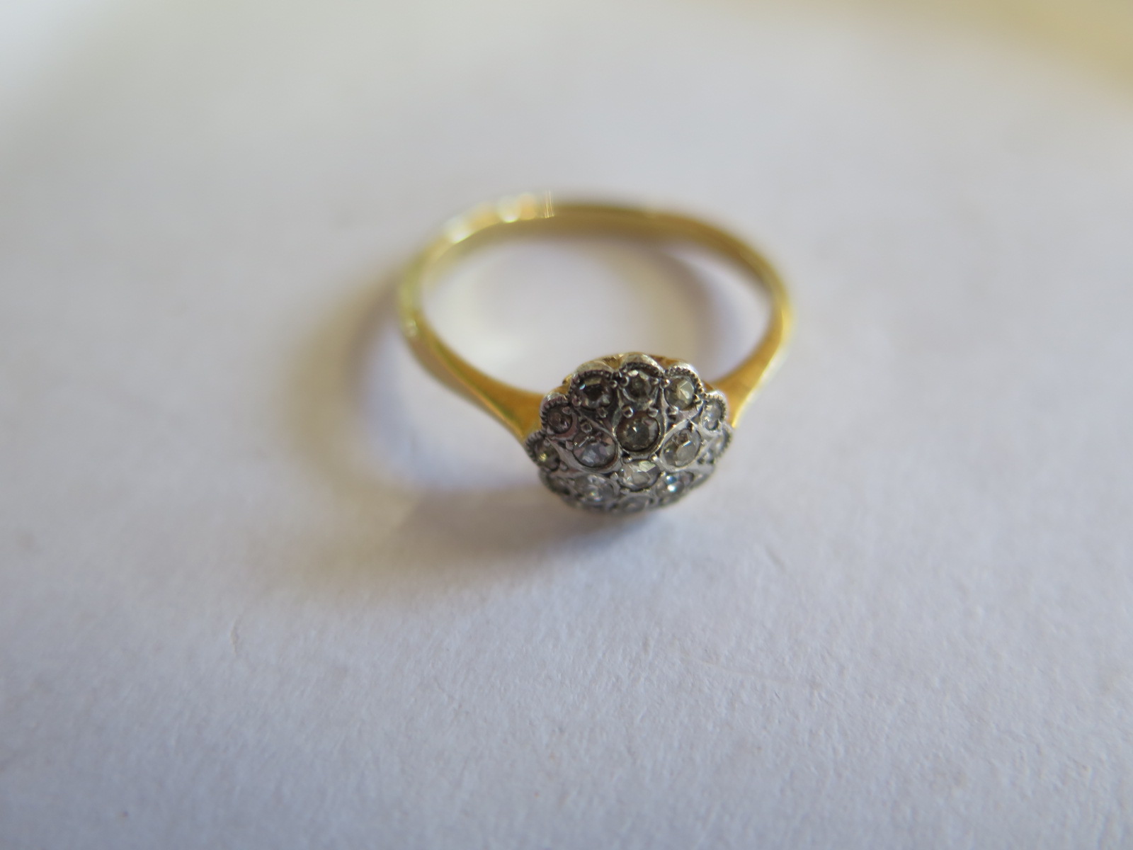 An 18ct yellow gold diamond cluster ring, size Q, approx 3 grams, some minor usage wear, marked 18ct