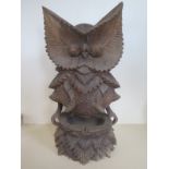 A carved owl figure, possibly black forest, 41cm tall, some general cracking to figure and minor