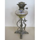 An ornate brass Griffin oil lamp with a clear glass font, good condition