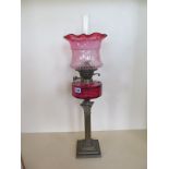 An oil lap with cranberry font and tinted shade, 70cm tall, good condition, some wear to base