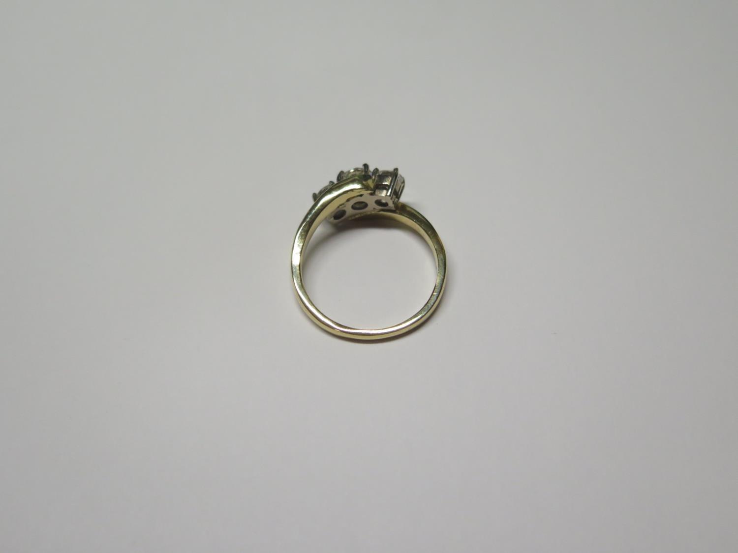 An 18ct yellow and white gold three stone crossover style ring - claw set with brilliant cut - Image 2 of 2