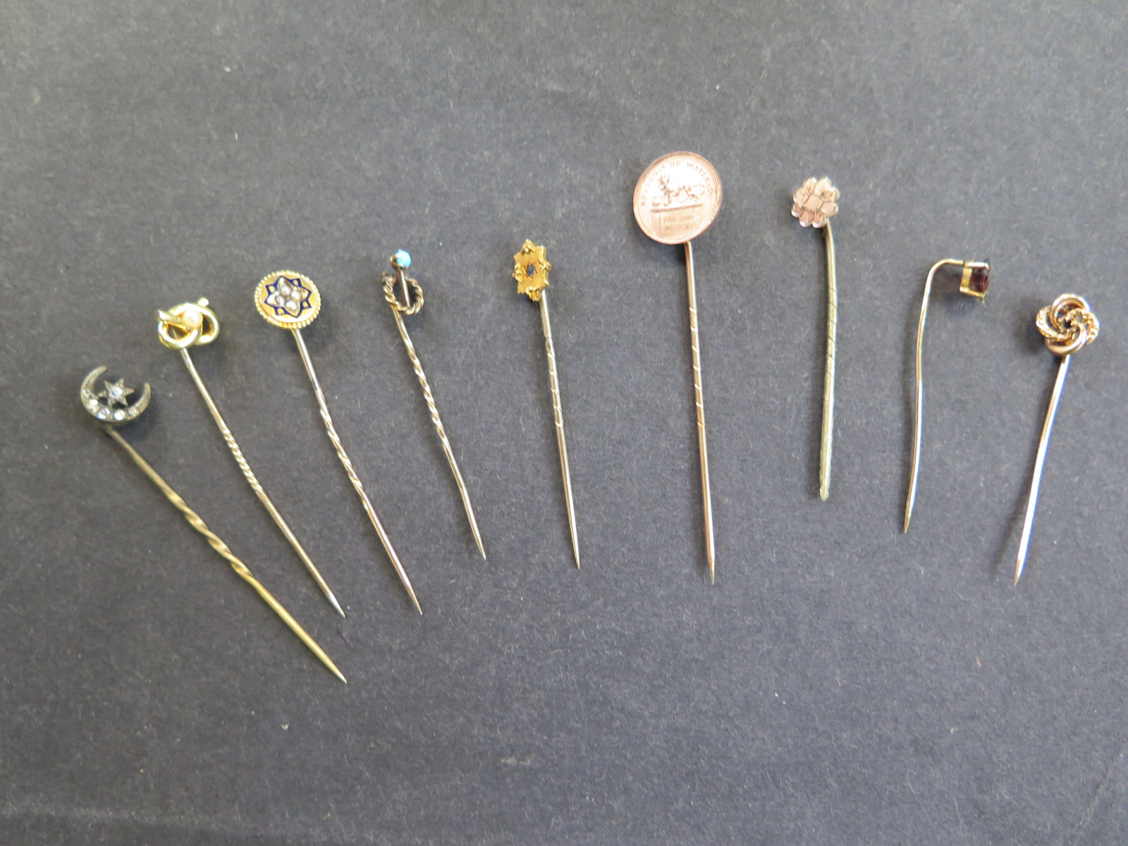 Nine tie pins to include two 15ct, approx 2.7 grams - one 10ct approx 1 gram, and a 9ct pin,