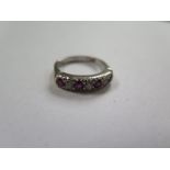 An 18ct white gold hallmarked diamond and ruby seven stone ring, size P, approx 6 grams, valued in