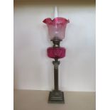 An oil lamp with cranberry tinted etched shade and cut glass cranberry font - 82 cm tall, chips to