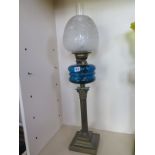 An oil lamp with blue glass font and etched shade, 79cm tall, minor chips to shade base, otherwise