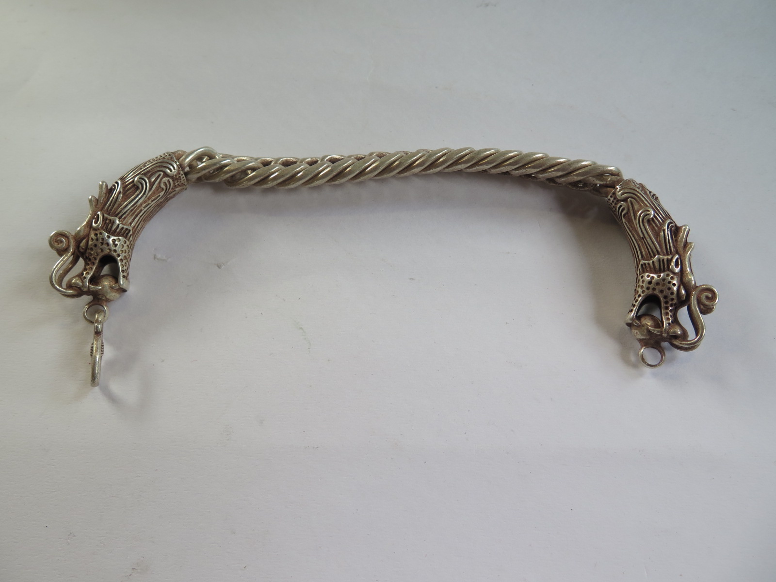 An oriental white metal dragon bracelet, 23cm long, good condition