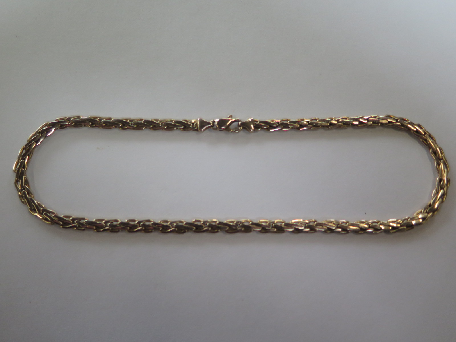 A plaited 9 carat gold necklace, approximately 42.5 cm long, with some signs of wear to clasp,