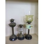 Three oil lamps, one with coloured glass font (font cracked) and green glass shade and two lamp