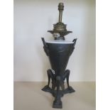 A cast iron oil lamp with triform base, 51cm tall, has been converted, reservoir drilled