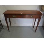 A mahogany hall table with walnut veneers, featuring two drawers raised upon tapered legs,