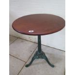 A mahogany side table on a painted cast iron base