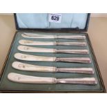 A boxed set of six silver handled butter knives - some usage but generally clean